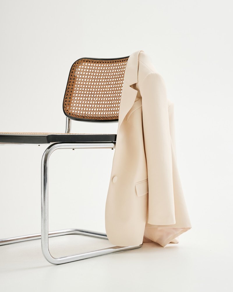 Rinascimento — editorial, cream jacket on a Cesca chair